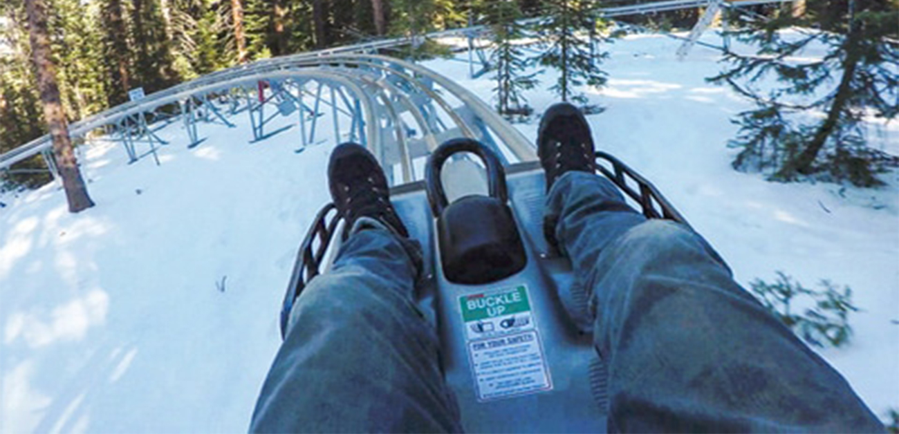 Man going down Snowmass Alpine Coaster during winter in Elk Camp Snowmass, Colorado  