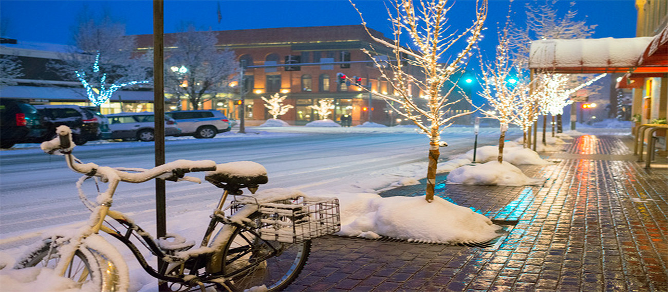 bicycle propped up during winter in downtown Aspen at night-time