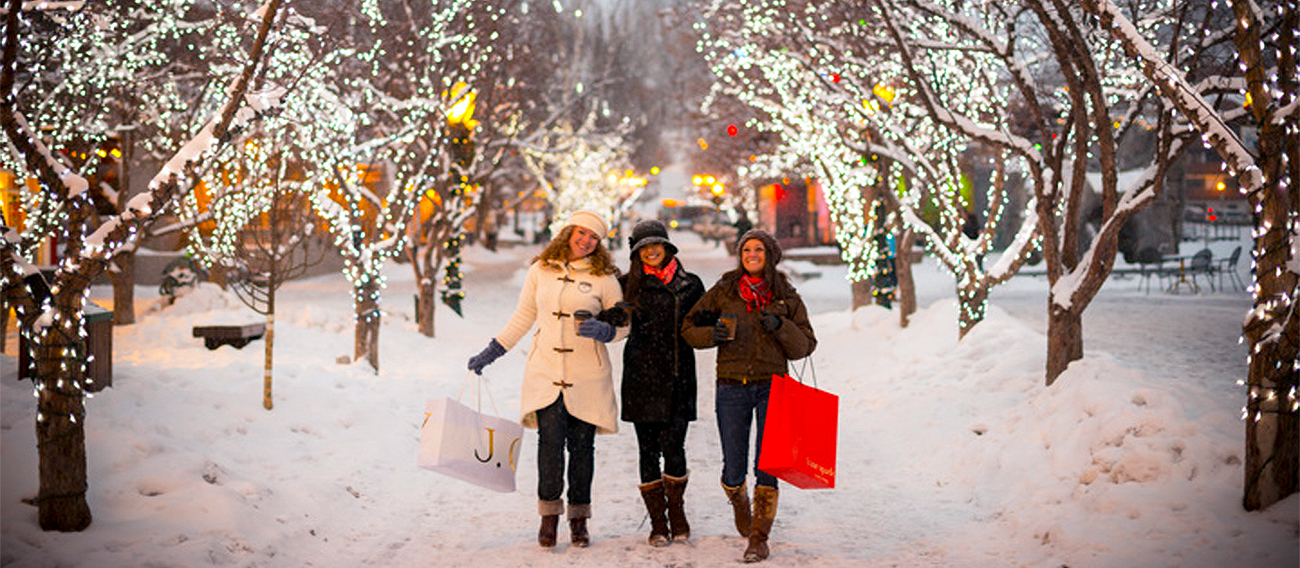 Three women walking down plaza in town of Aspen, Colorado during winter