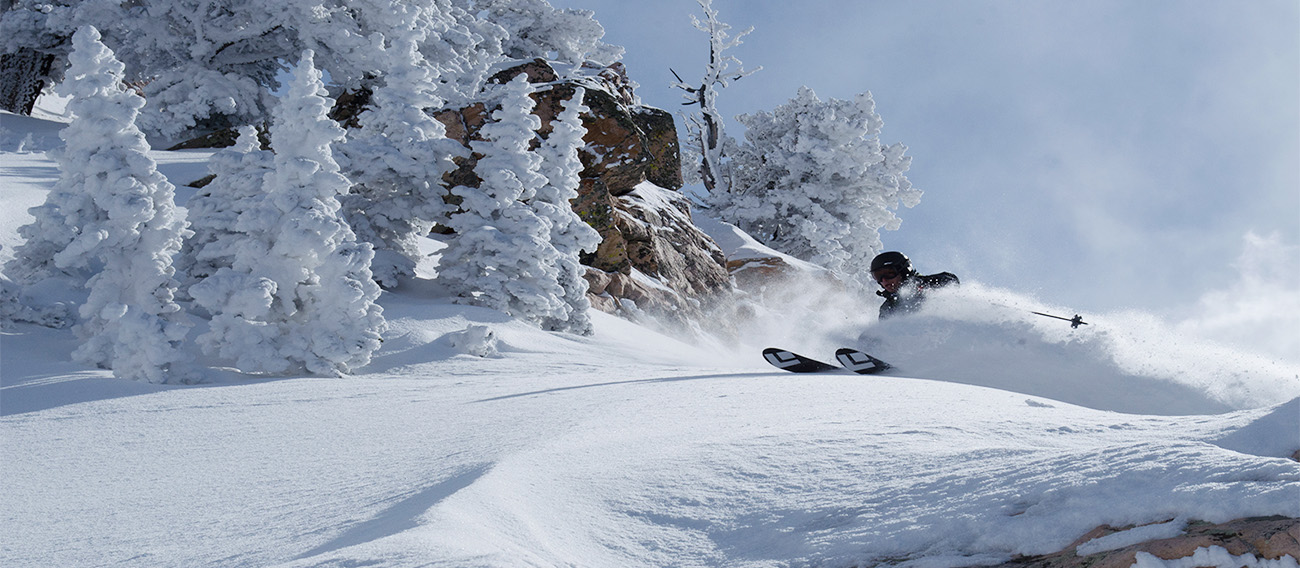 Man Backcountry skiing down the backside of Aspen Mountain in Aspen, Colorado with deep snow