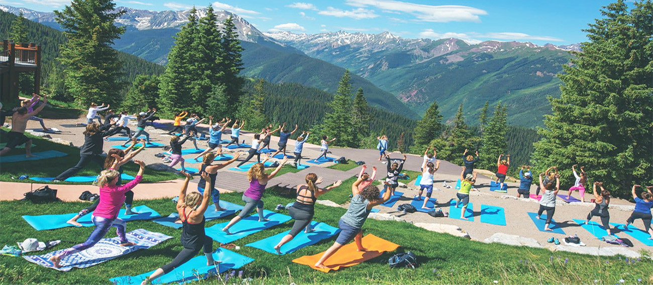 Large group of people doing Yoga on top of Aspen Mountain in Aspen, Colorado