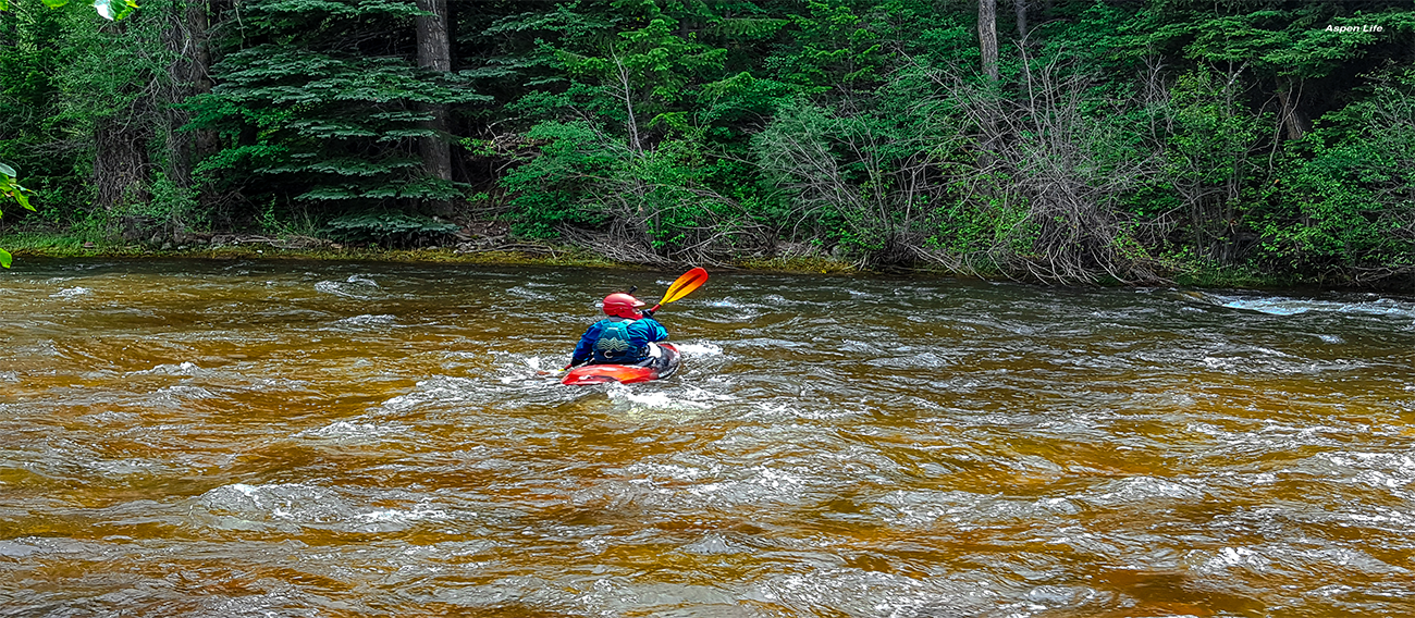 Man kayaking down the middle of the Rio Grande River in Aspen, Colorado in July 2024